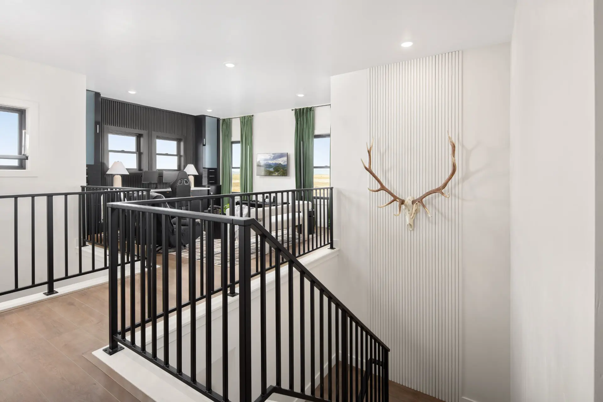 Upstairs landing with black railings overlooking an office and a slatted accent wall