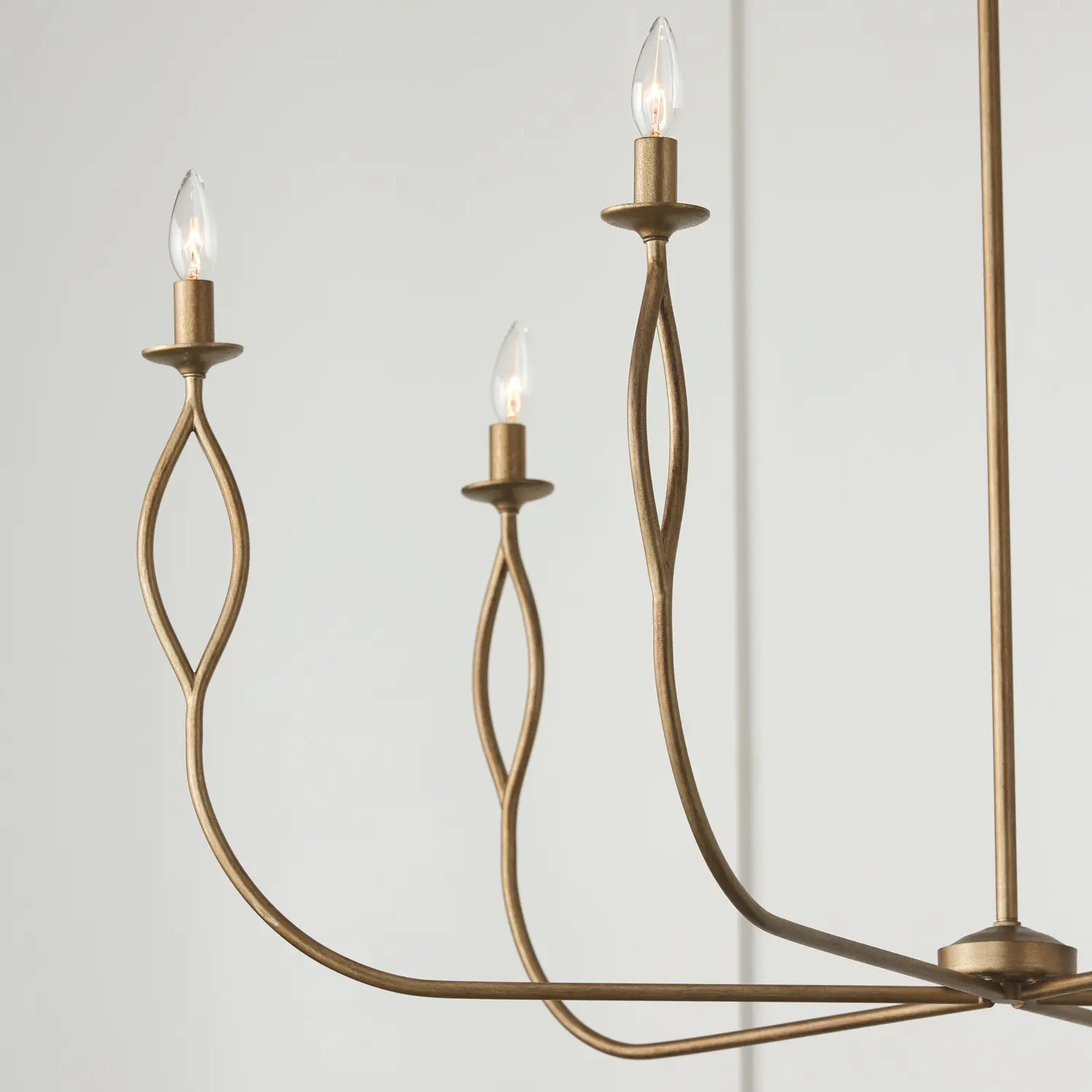 Close-up of a brass chandelier arm with candle-style bulbs