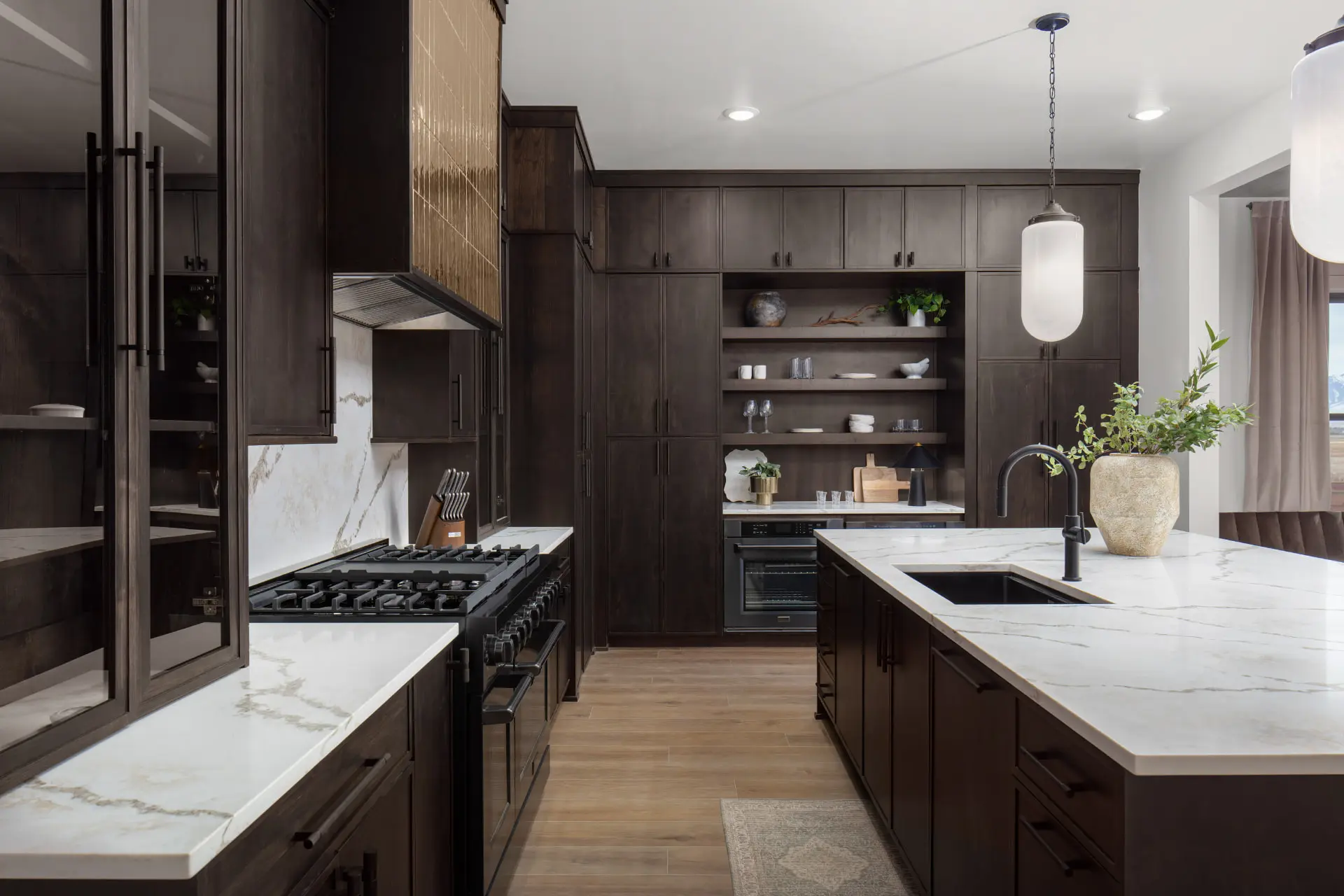 Galley view of the walnut kitchen with open shelving and a frosted glass pendant over the sink