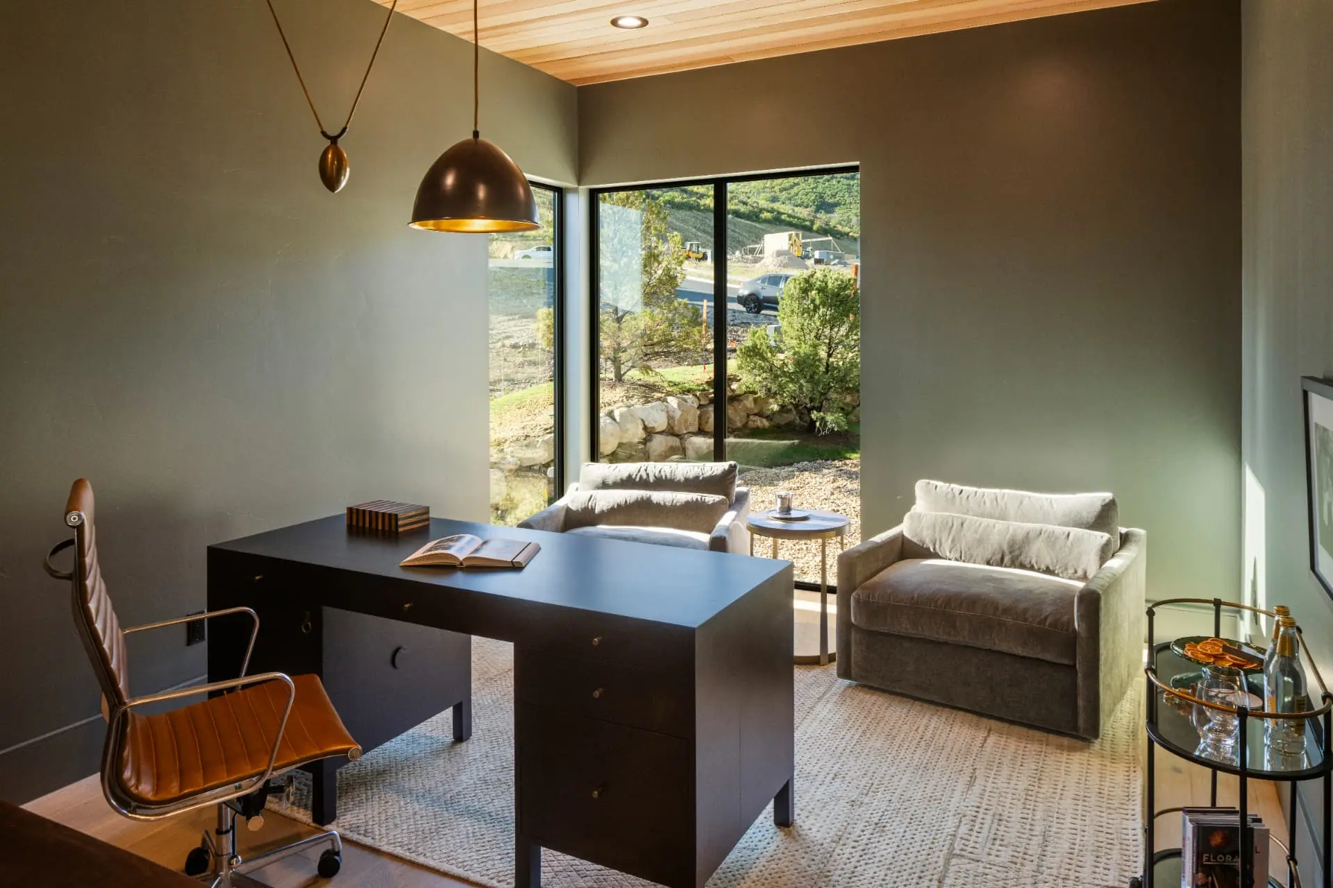 Home office with a brass dome pendant and a slim pendant sconce over the desk