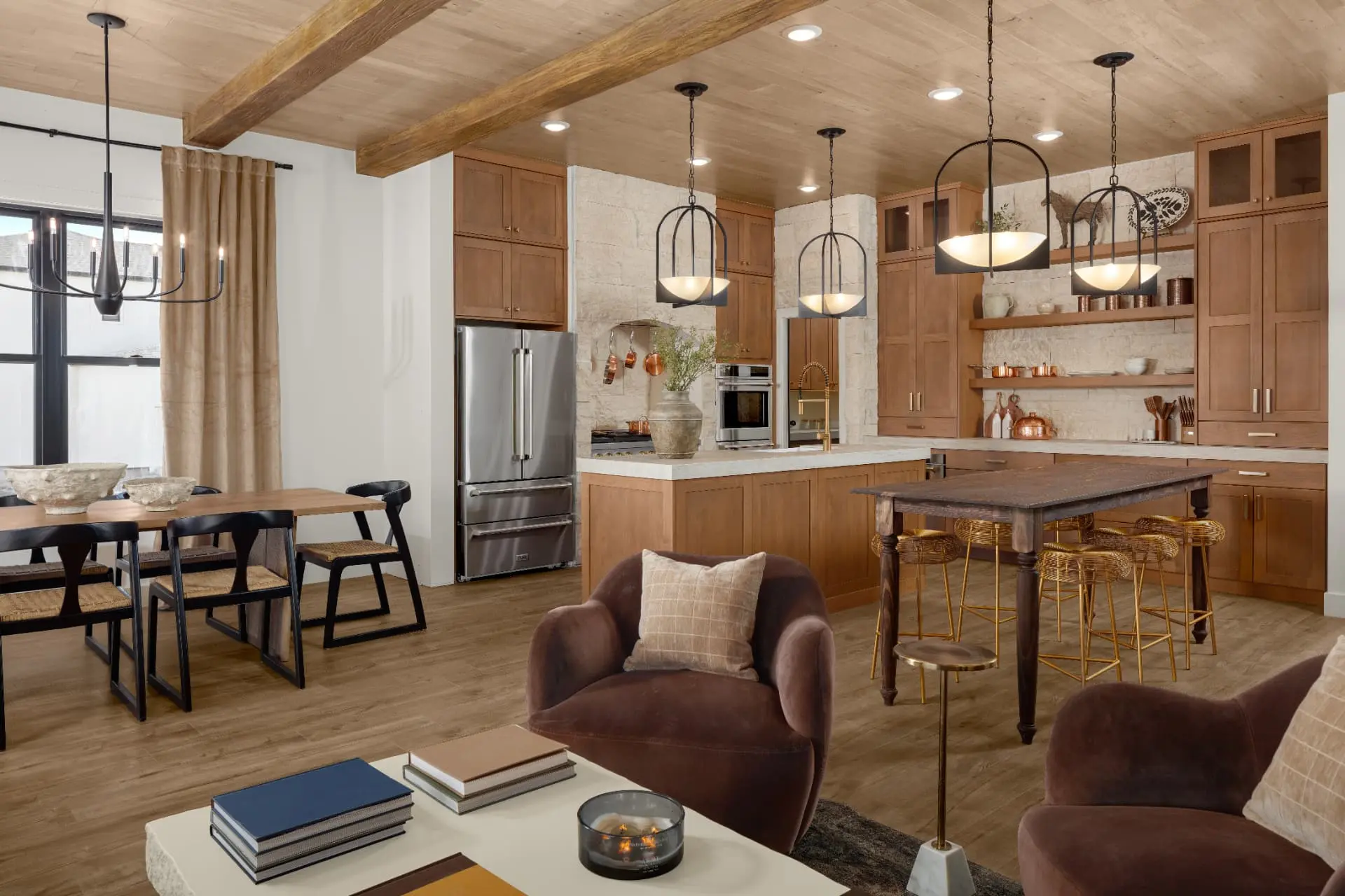 Open kitchen and dining space with arched iron pendants and a forged iron chandelier