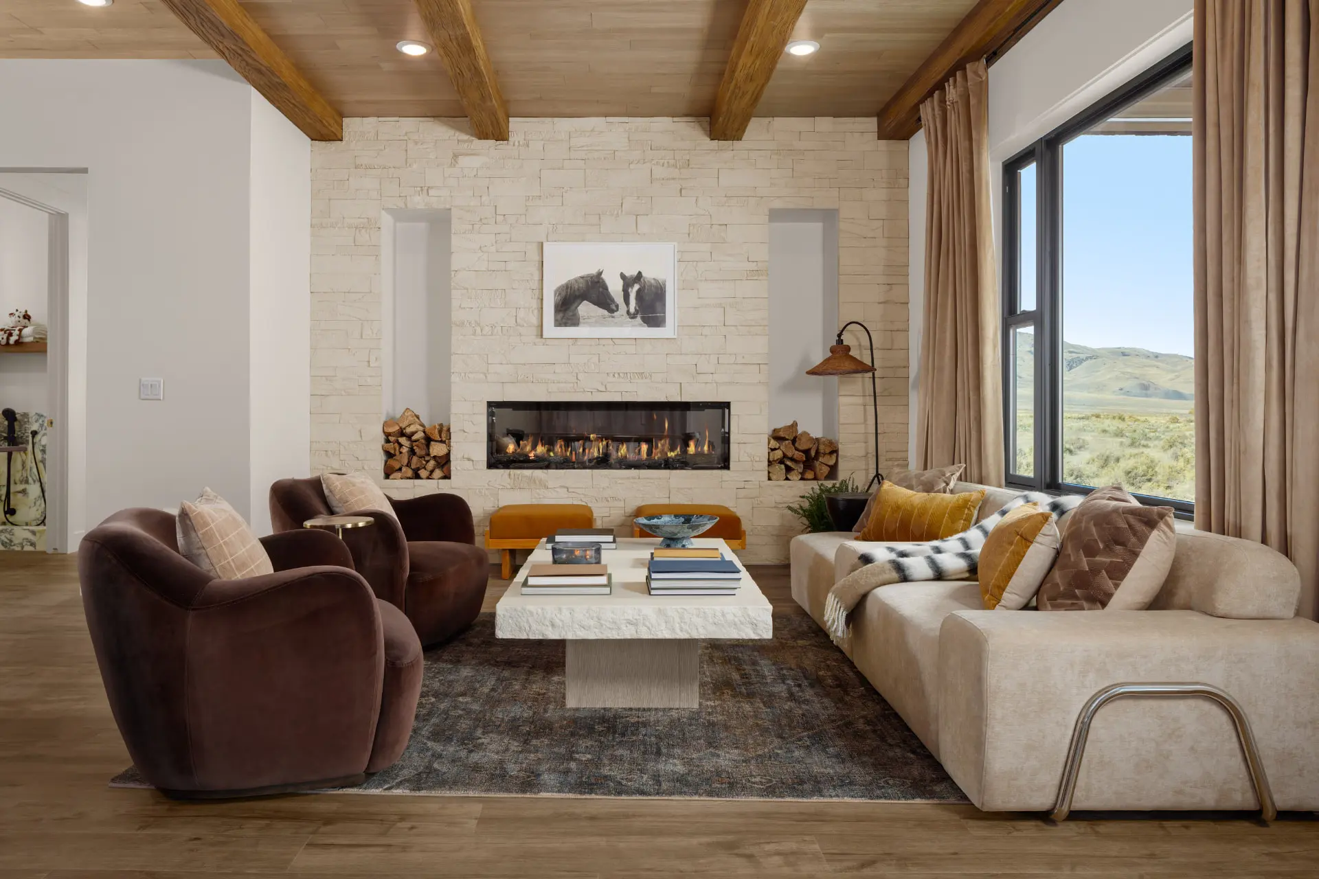 Great room with a stacked stone fireplace, beamed white oak ceiling and valley views