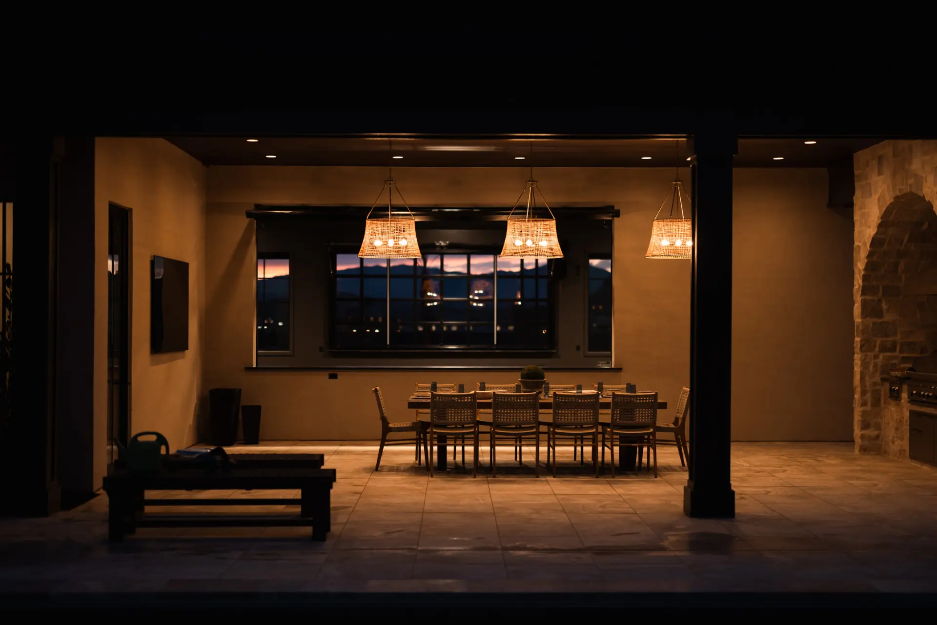 Outdoor kitchen and dining lit warmly against a desert sunset