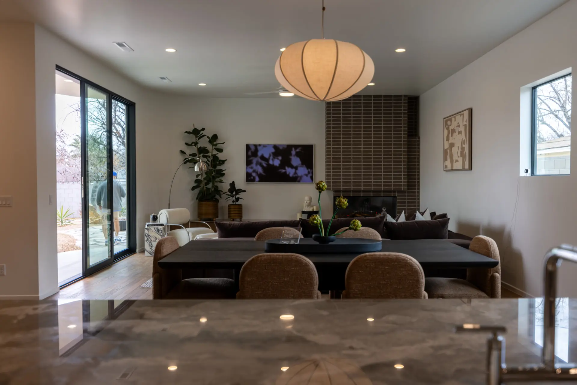 Linen globe pendant above a dark dining table in an open-plan Downtown St. George home