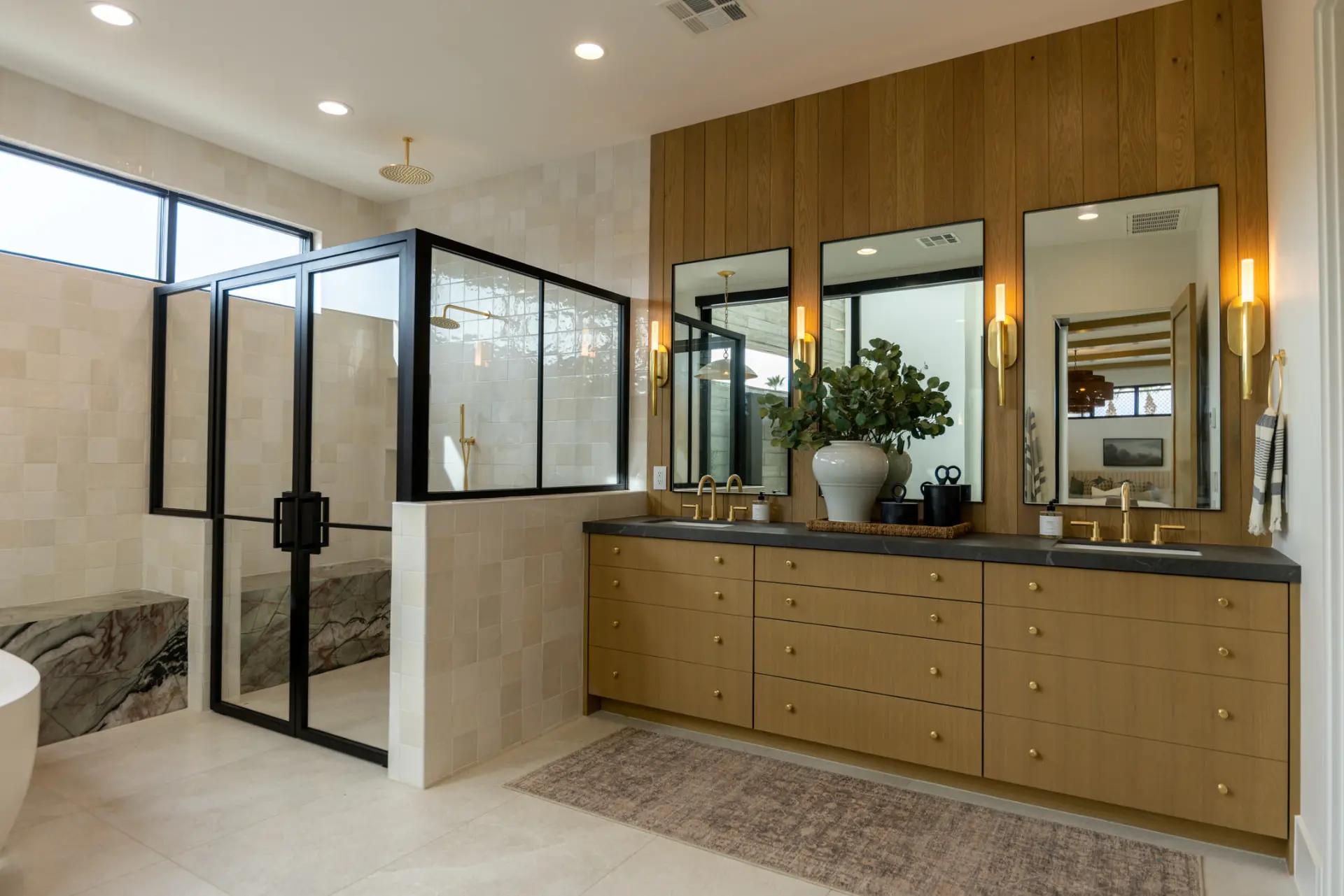 Primary bath vanity with slim brass sconces between three mirrors