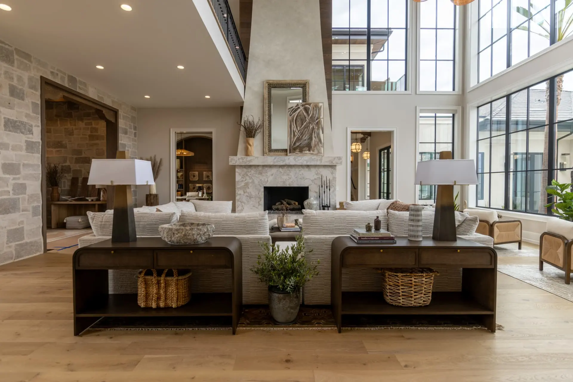 Stone-walled great room with plaster fireplace and layered table lamps
