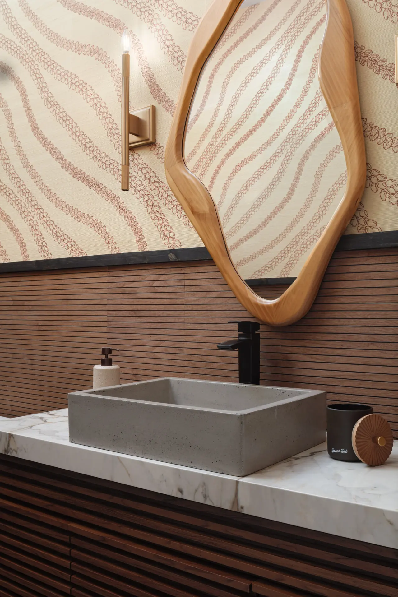 Powder room with patterned grasscloth, a reeded brass sconce and a concrete vessel sink