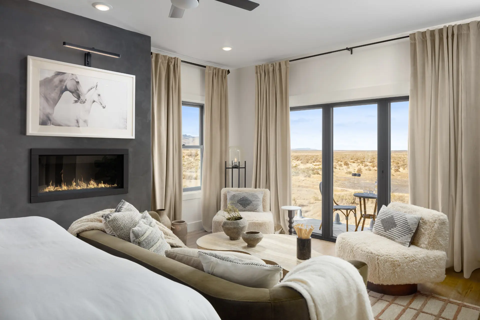 Primary bedroom with a plaster fireplace wall, picture light and desert views