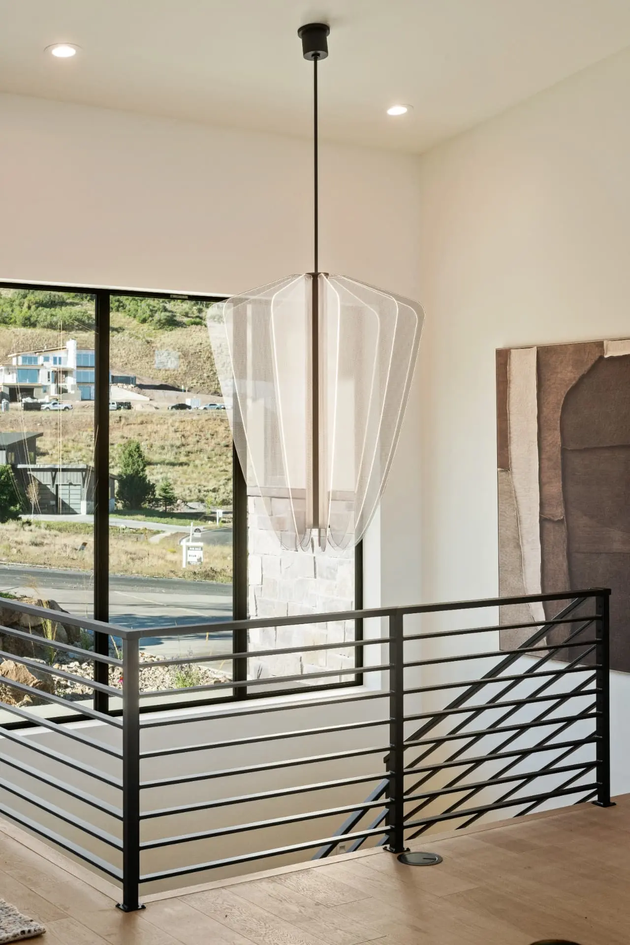Oversized shaded pendant above a stair landing in a Heber, Utah home