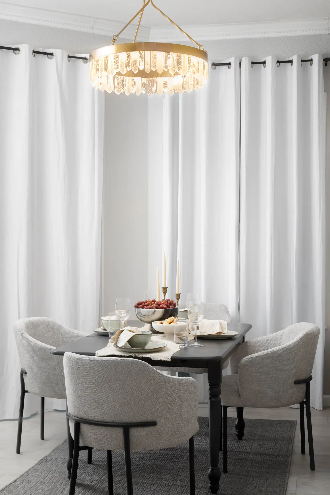 Dining room with a brass and quartz prism ring chandelier above a black table