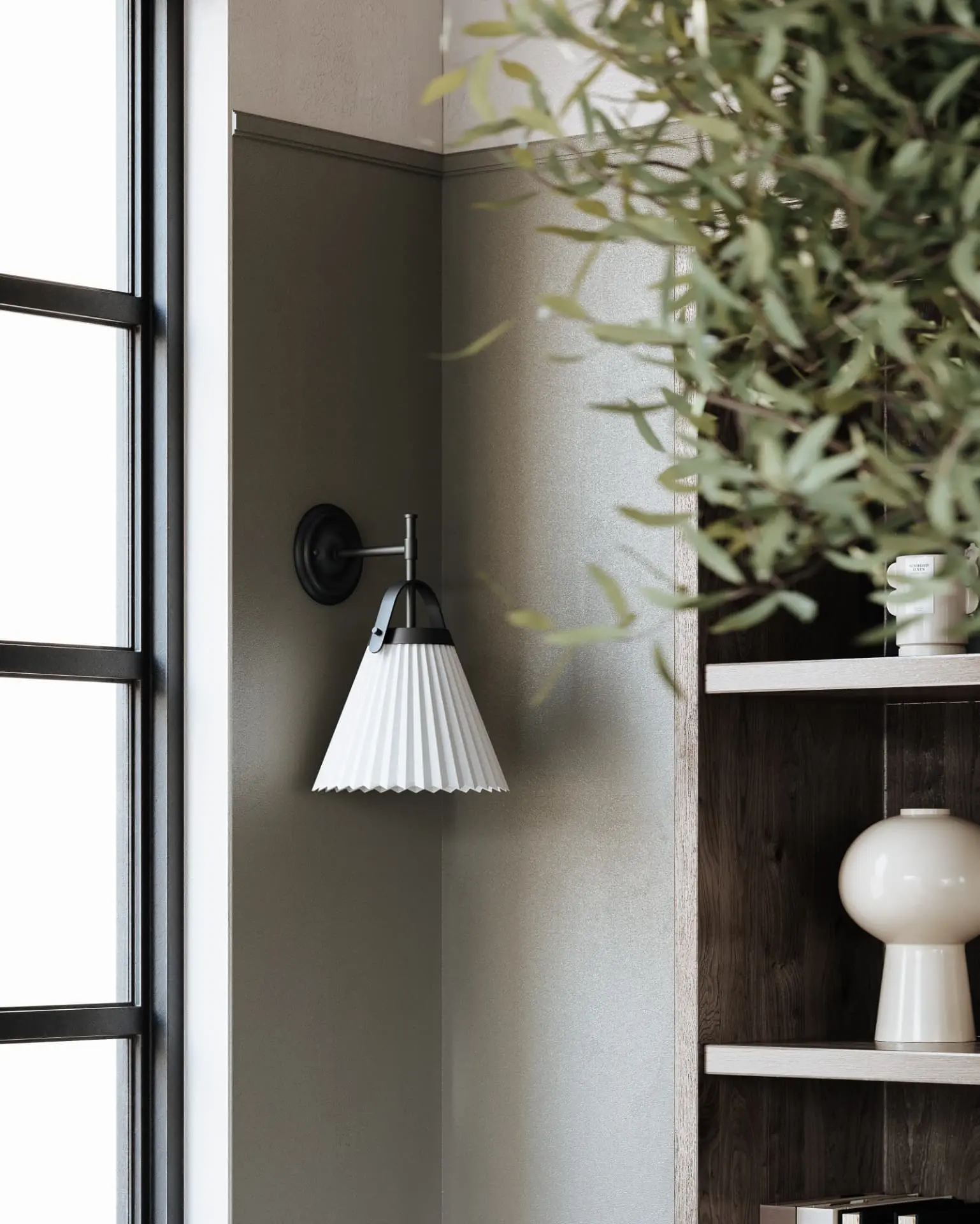 Black wall sconce with a white pleated shade beside a window and styled oak shelving