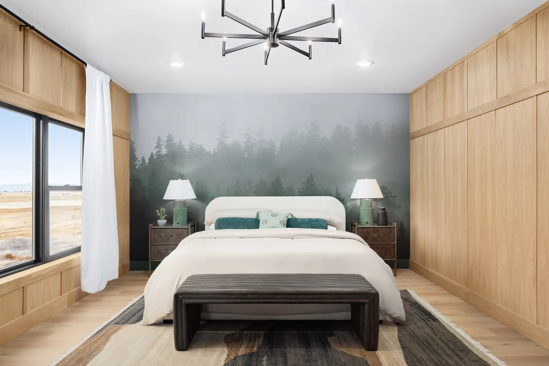 Primary bedroom with a spoked chandelier and forest mural wall
