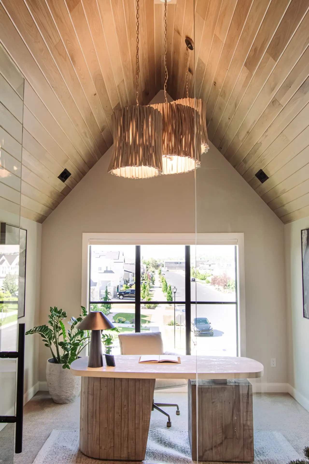 Vaulted white oak office with a driftwood drum chandelier above a rounded wood desk