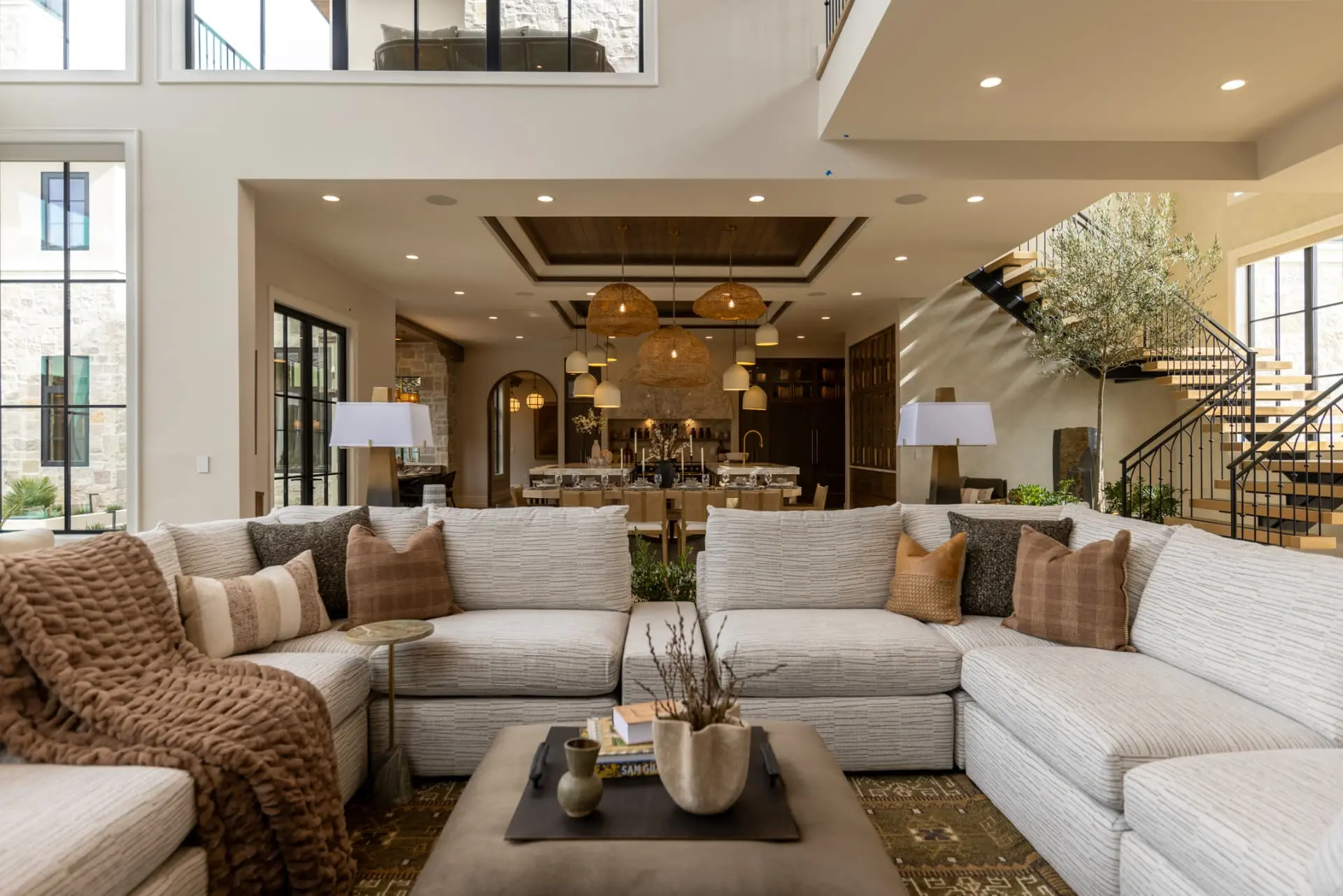 Sectional seating looking through to the kitchen and woven pendant cluster
