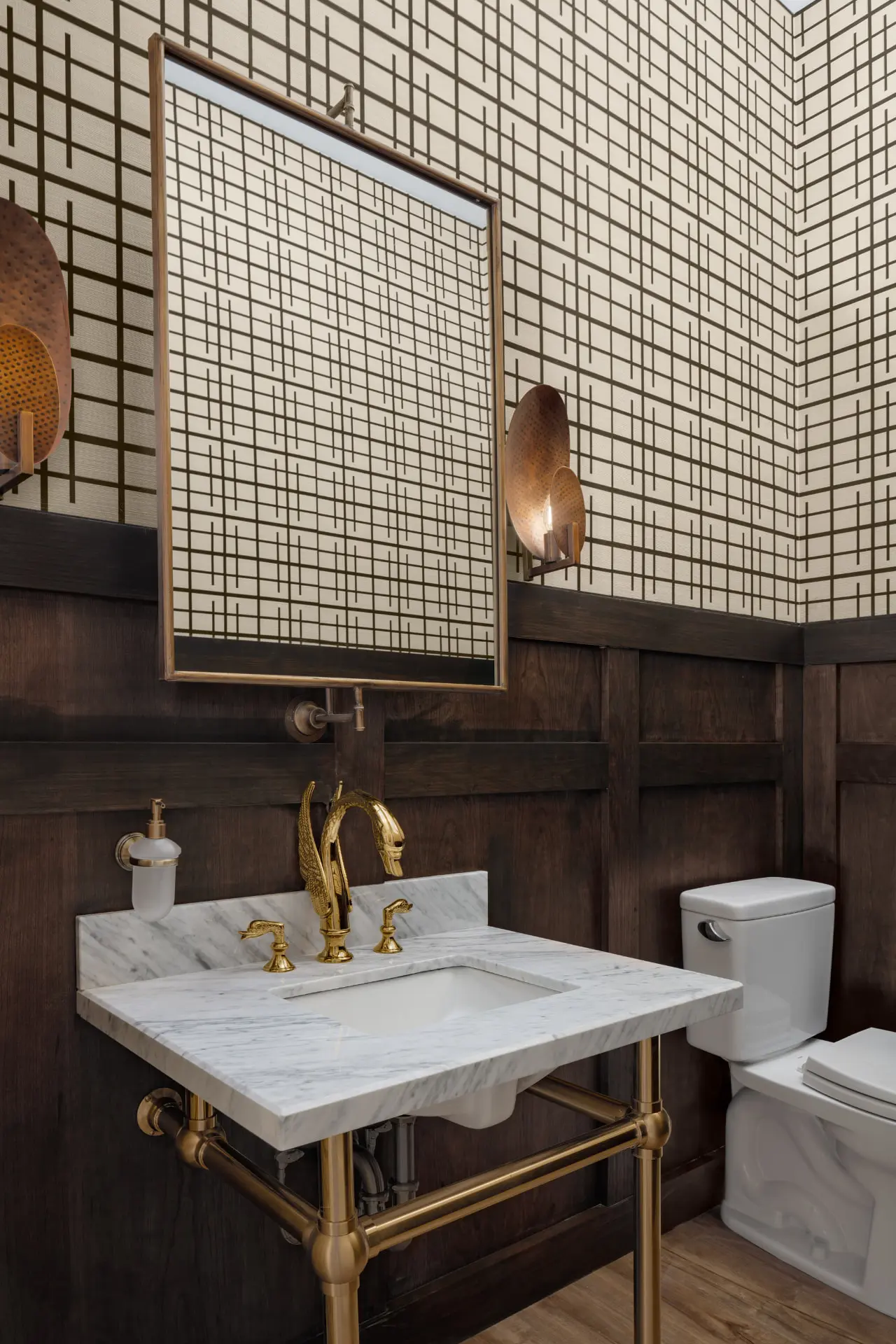 Powder room with graphic wallpaper, walnut wainscot and hammered copper wall sconces